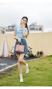 Borsa a mano rosa con trama litchi e doppi manici in un ambiente outdoor e alla moda
