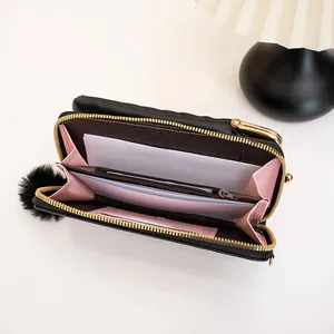Black quilted crossbody wallet phone bag with gold zipper and plush ball charm decoration