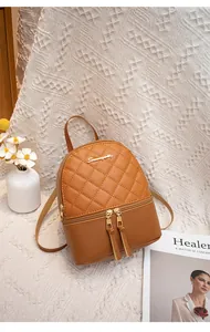 Detail of caramel mini backpack featuring diamond quilted faux leather and gold metal logo