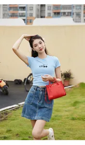 Dettaglio della borsa a mano rosso brillante con trama in pelle e tracolla sottile