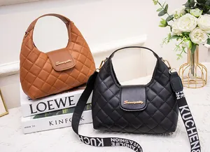 Close-up of quilted PU leather handbag with metal logo and printed wide strap