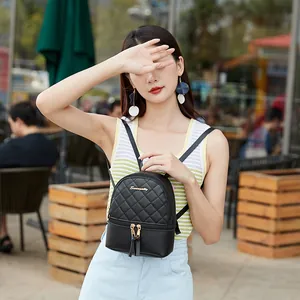 Women's black quilted mini backpack with diamond pattern and gold zipper details