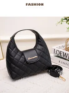 Detail showing black quilted PU leather hobo bag with gold logo and wide patterned strap