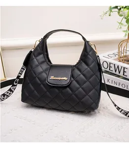 Detail of black quilted hobo bag with gold logo and stylish jacquard wide strap