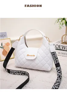 Close-up of white quilted PU leather handbag with wide lettered strap and gold hardware