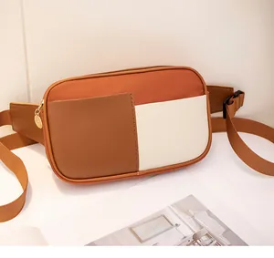 Detail of color-block canvas waist bag showing premium gold zipper and leather texture