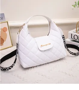 Detail of white quilted crossbody bag with golden logo and printed shoulder strap