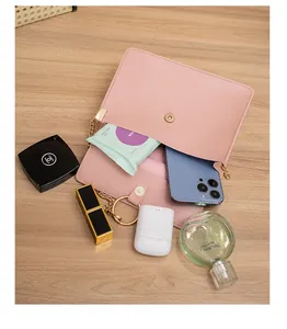 Pink PU leather crossbody bag with gold chain showing internal storage for cosmetics