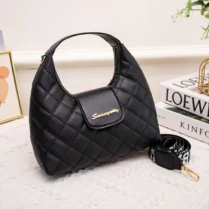 Black quilted hobo bag with gold metal logo and patterned wide shoulder strap