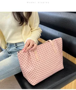 Close-up of pink tote bag with geometric floral patterns and gold metal rivets details