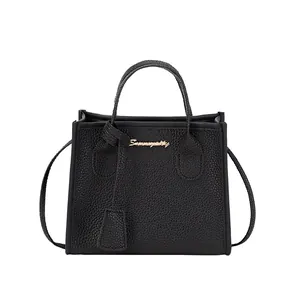Borsa a mano classica in pelle nera motivo litchi con logo dorato e tracolla sottile
