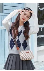 Detail of crossbody camera bag with check pattern and adjustable wide shoulder strap
