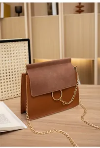 Detail view of brown and burgundy patchwork crossbody bag with gold ring buckle