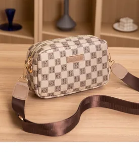 Detailed view of checkered camera bag with HORHE logo and wide fabric shoulder strap