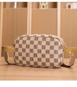 Detail of the letter-printed checkerboard crossbody bag with golden zipper and strap buckle