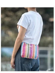 Detail der bunten Regenbogen-Webtasche mit goldenem Flamingo-Anhänger und Kettenriemen