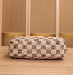 Close-up of brown checkerboard fabric with vintage letter patterns on a square crossbody bag