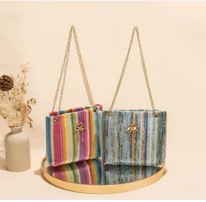 Details von Regenbogen-Webtaschen mit eleganten Goldflamingo-Anhängern und feinen Kettenriemen