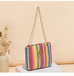 Makroaufnahme der Regenbogen-Webtasche mit goldenem Schwanenanhänger und Metallkette