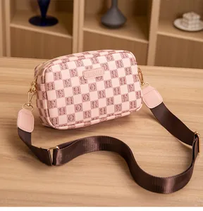 Detail of pink checkerboard crossbody bag with HORHE logo and adjustable strap