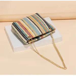 Detail der bunten geflochtenen Beuteltasche mit goldener Kette und Regenbogenstreifen