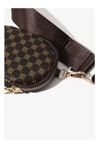 Detail einer dunkelbraunen Münztasche aus Leder mit goldenen Elementen und Nylonband