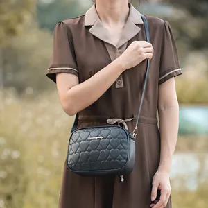 Bolso bandolera negro para mujer con textura de corazón acolchado y detalles dorados