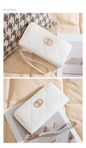 Detail of white quilted long wallet featuring gold double-ring hardware and wrist strap