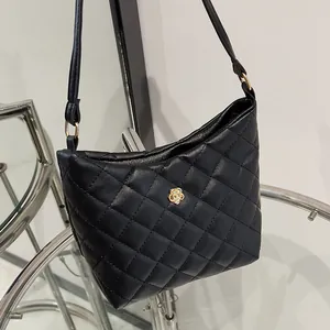 Elegante borsa hobo in pelle trapuntata nera con camelia dorata e tracolla sottile