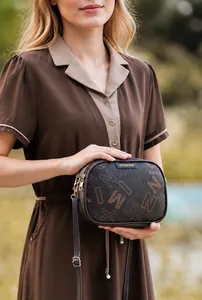 Λεπτομέρεια καφέ τσάντας PU leather με κομψό τύπωμα γραμμάτων και χρυσά μεταλλικά στοιχεία