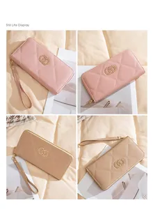 Detail of long quilted wallet with wrist strap and gold interlocking ring hardware