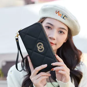Elegant black quilted long wallet with gold ring hardware and convenient wrist strap