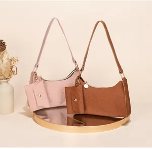 Detail of embossed texture and matching mini pouch on pink and brown underarm bags