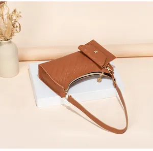Detail of caramel brown woven leather shoulder bag with gold clasp and textured finish