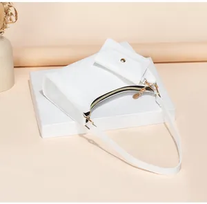 Detailed view of white textured hobo bag with gold zipper and detachable mini pouch