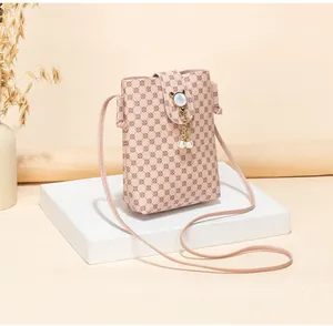 Detail of pink crossbody phone bag with floral pattern and pearl cat-ear clasp