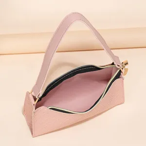 Pink embossed underarm tote bag with gold hardware and wide shoulder strap