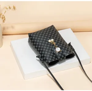 Close-up of printed mini phone bag featuring pearl charm and geometric pattern