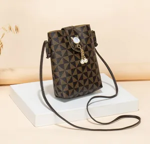 Detailed view of phone bag with geometric pattern, cat-ear buckle and pearl pendant