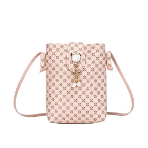 Pink printed vertical crossbody phone bag with floral pattern and pearl charm pendant