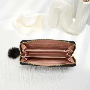 Elegant black long wallet for women featuring heart embroidery and a plush pom-pom charm