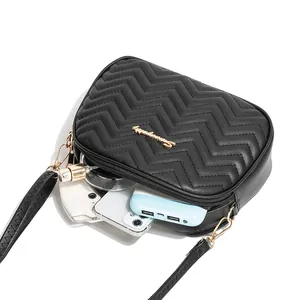 Black quilted wave stitch crossbody bag showing interior capacity for phone and perfume
