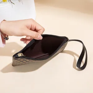 Pochette classica marrone con monogramma, cinturino da polso e cerniera nera fluida
