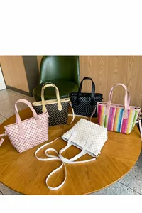 Detalle de cinco bolsos tote tejidos de colores con correas de cuero ajustables
