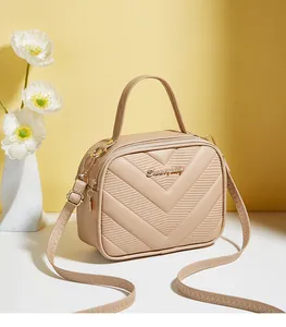 Close-up of nude crossbody bag with V-quilted faux leather and gold metal logo