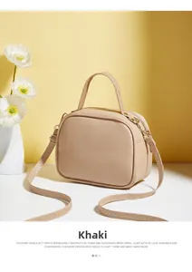 Detail of khaki square crossbody bag featuring textured V-pattern and double zipper closure