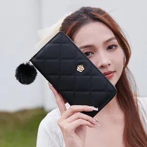 Elegant black quilted long wallet for women featuring a gold flower clasp and pompom charm