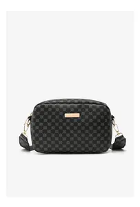Detail of crossbody camera bag with black geometric circle pattern and gold metal hardware