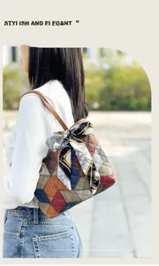 Outdoor view of multi-color geometric patchwork handbag with decorative silk scarf