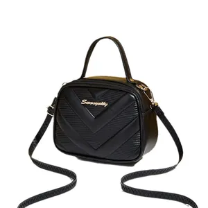 Chic black V-quilted faux leather crossbody bag with top handle and wavy strap detail